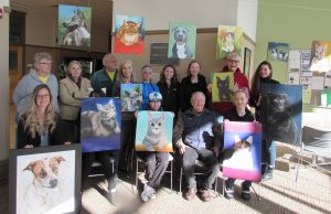 Students from CCC art class pose with paintings of animals from the local animal shelter