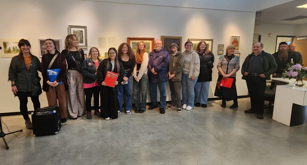 Students who participated in the art show gather for a photo in the art gallery