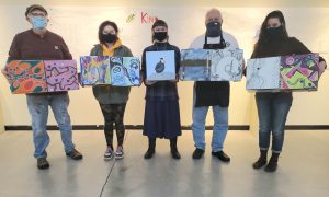 From left to right: CCC Painting students Jeff Donnelly, Allyson Preston, Arianna Nelson, Dick Magathan, and instructor Kristin Shauck showing off boxes by various participating CCC art students.